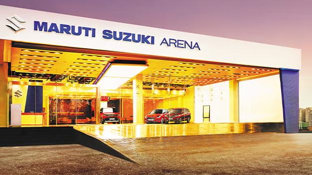 A Maruti Suzuki ARENA showroom lit up in the evening