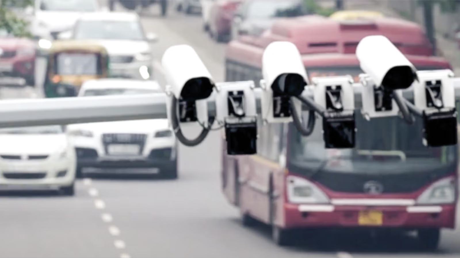 Traffic on an Indian road beneath speed cameras