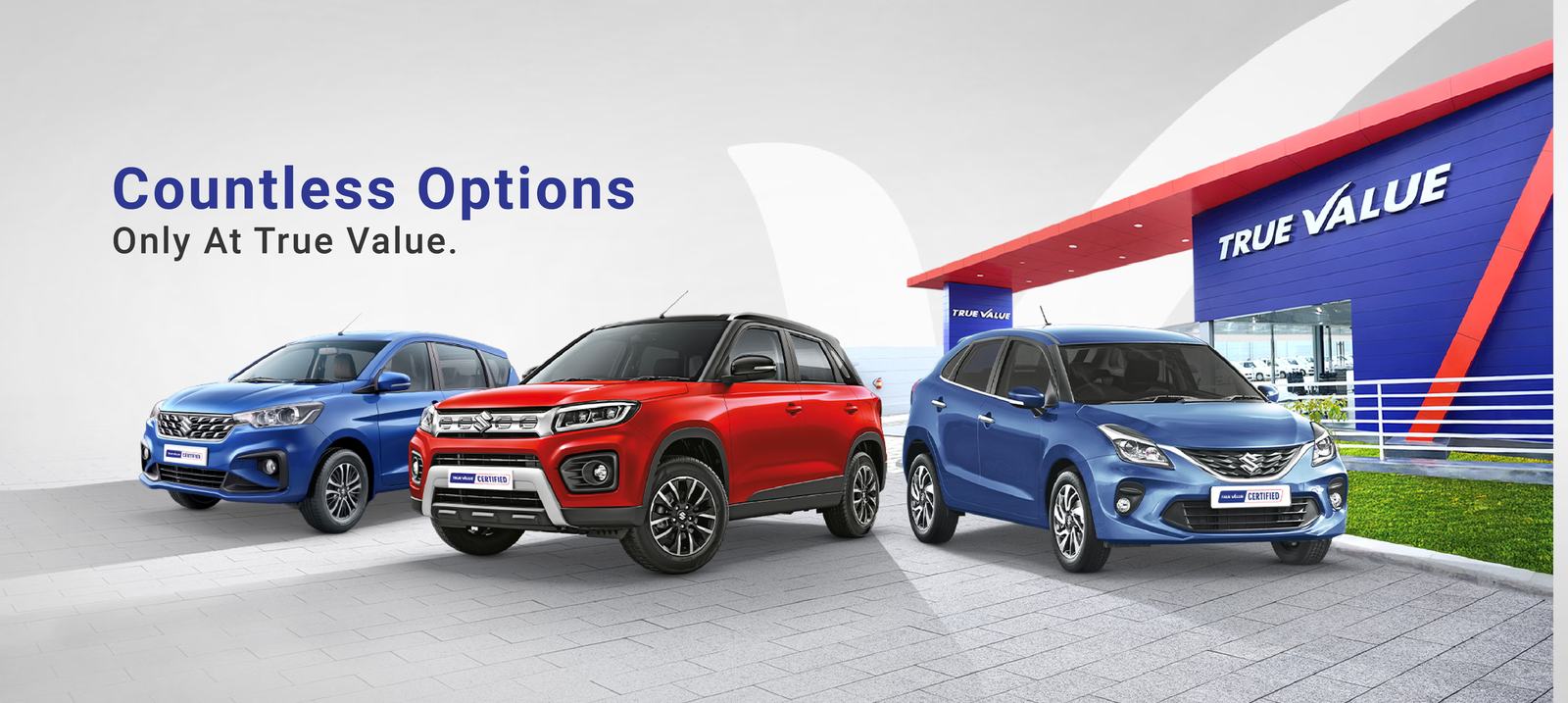 Three cars outside a Maruti Suzuki True Value outlet